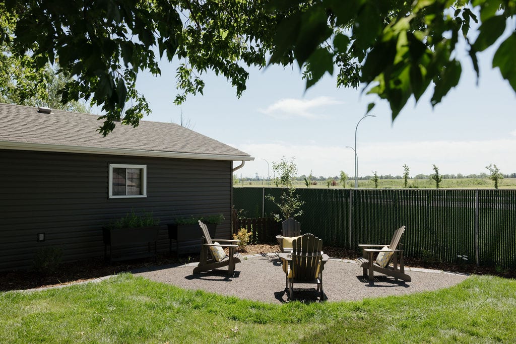 Backyard fire pit area with Adirondack chairs