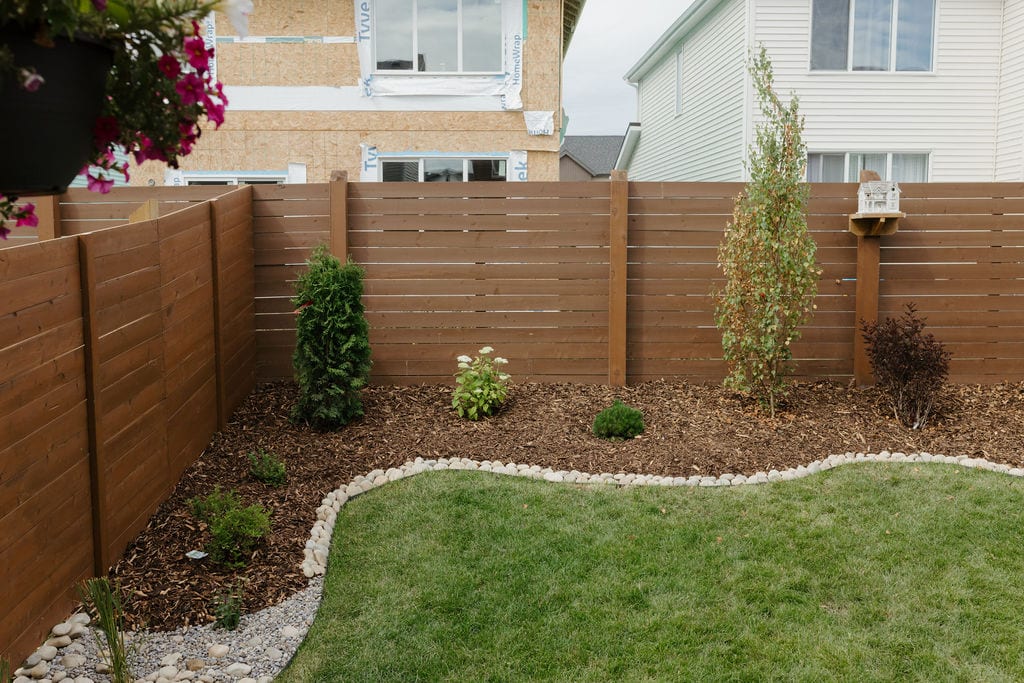 Horizontal cedar privacy fence with planting bed and new sod