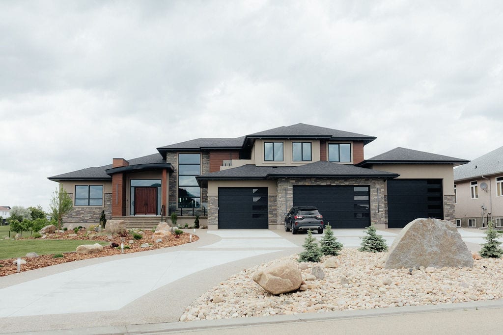 Finished front yard landscaping with rock beds and shrubs at a modern Edmonton-area home